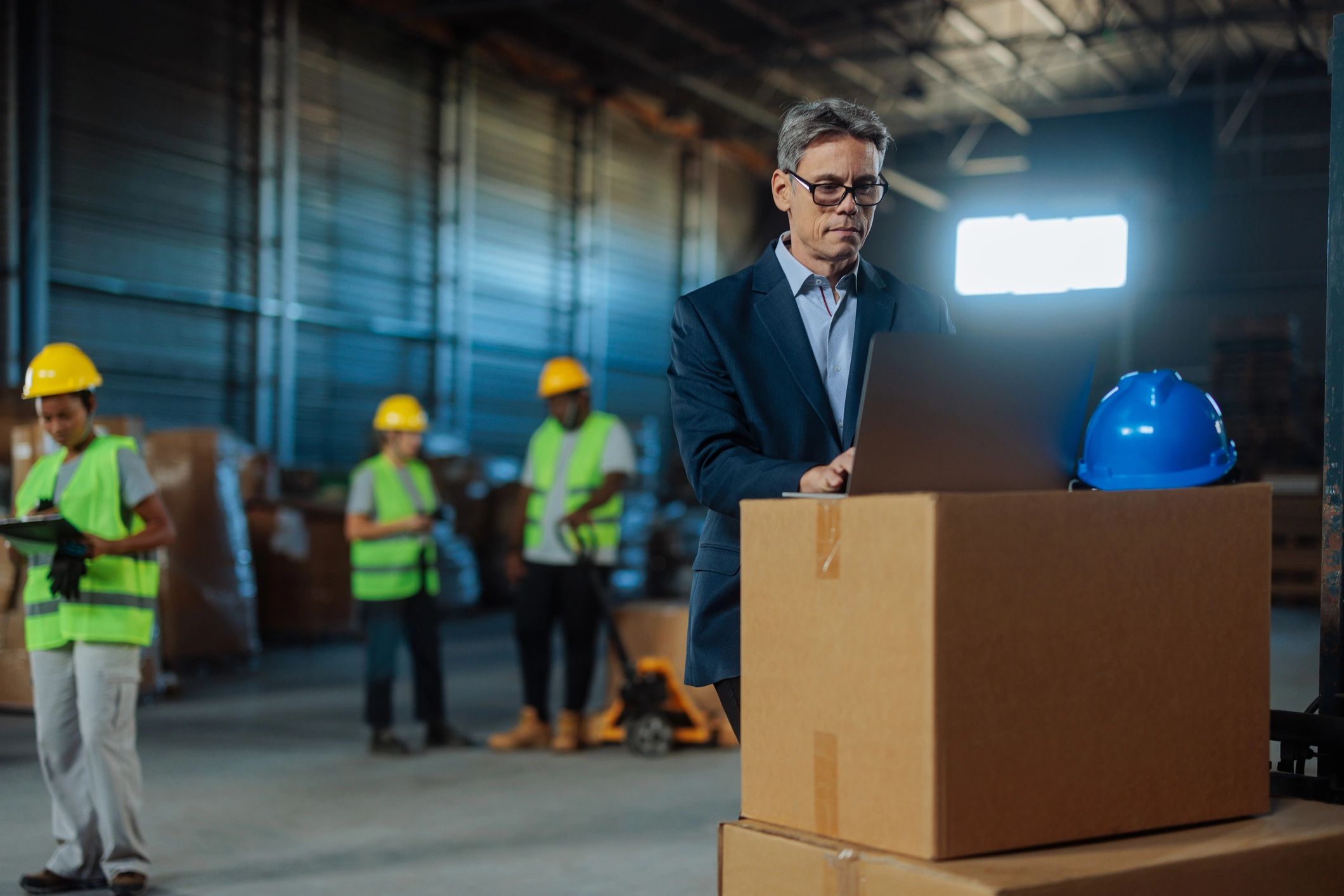 Manager using laptop for ecommerce operations in warehouse